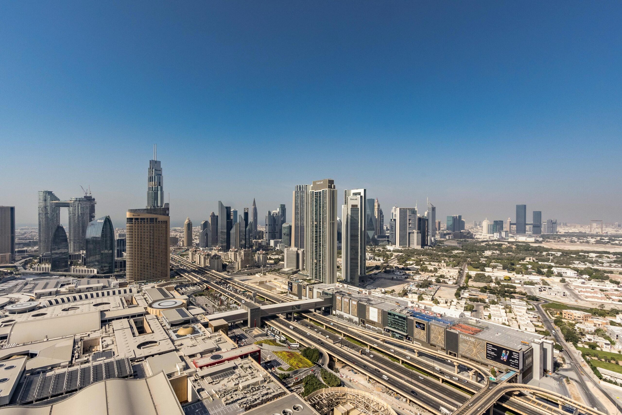 Panoramic aerial view of Dubai's skyline, showcasing modern skyscrapers and urban landscape.